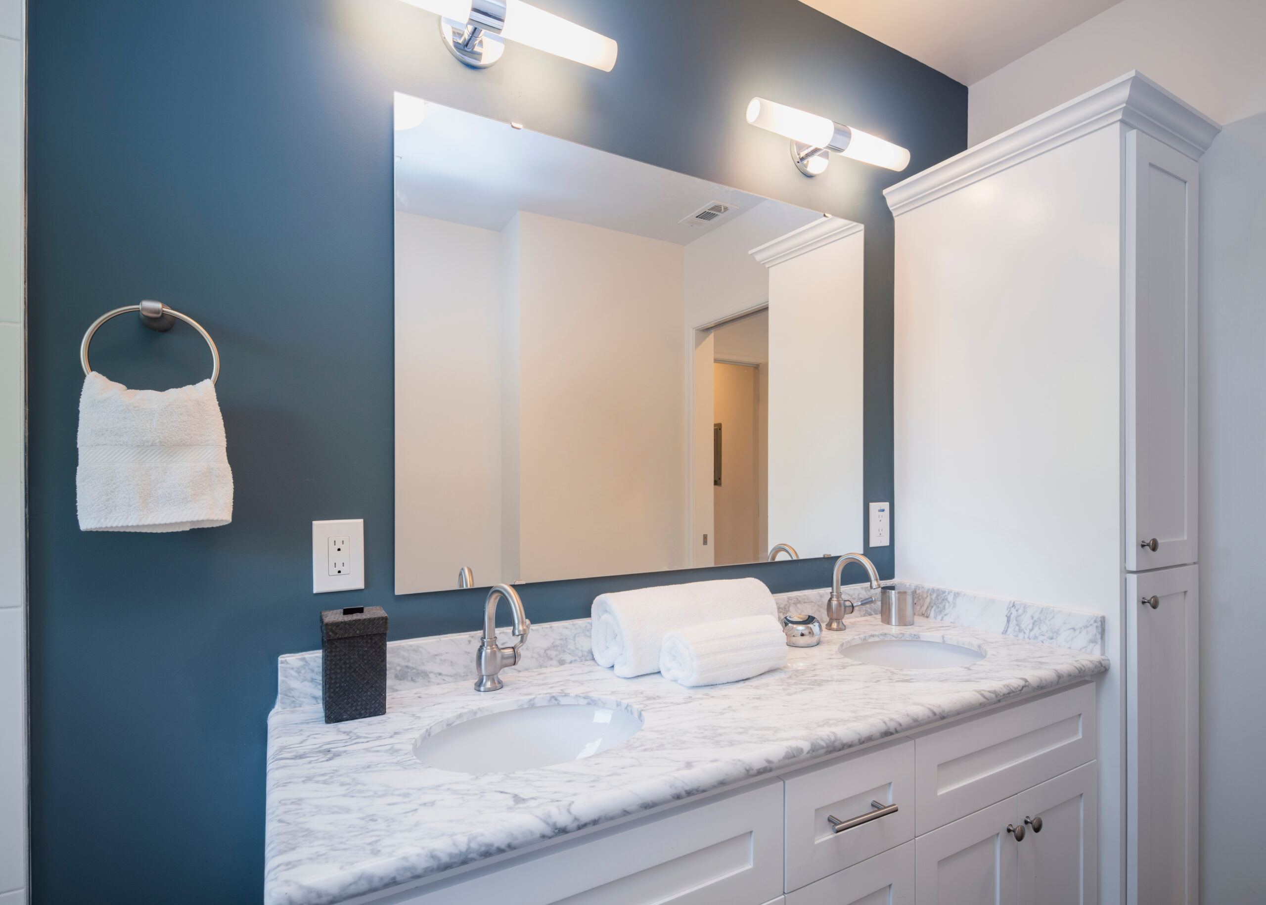 Blue and white bathroom with oval marble double sink.