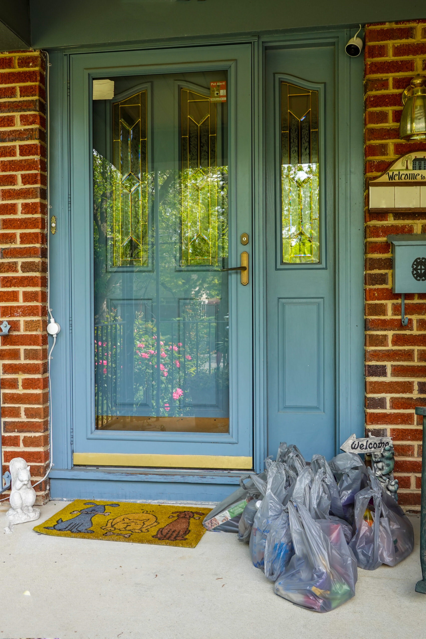 Groceries in plastic bags that have been delivered to the front door of a home