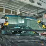 Two individuals wearing gloves are carefully positioning a new windshield onto a dark vehicle using yellow suction cup tools in an auto repair shop. Glacier_Glass_Regina Glacier_Glass_Regina Glacier_Glass_Regina Glacier_Glass_Regina Glacier_Glass_Regina Glacier_Glass_Regina Glacier_Glass_Regina Glacier_Glass_Regina Glacier_Glass_Regina Glacier_Glass_Regina Glacier_Glass_Regina Glacier_Glass_Regina Glacier_Glass_Regina Glacier_Glass_Regina Glacier_Glass_Regina Glacier_Glass_Regina Glacier_Glass_Regina Glacier_Glass_Regina Glacier_Glass_Regina Glacier_Glass_Regina Glacier_Glass_Regina Glacier_Glass_Regina Glacier_Glass_Regina Glacier_Glass_Regina Glacier_Glass_Regina Glacier_Glass_Regina Glacier_Glass_Regina Glacier_Glass_Regina Glacier_Glass_Regina Glacier_Glass_Regina Glacier_Glass_Regina Glacier_Glass_Regina Glacier_Glass_Regina Glacier_Glass_Regina Glacier_Glass_Regina Glacier_Glass_Regina Glacier_Glass_Regina Glacier_Glass_Regina Glacier_Glass_Regina Glacier_Glass_Regina Glacier_Glass_Regina Glacier_Glass_Regina Glacier_Glass_Regina Glacier_Glass_Regina Glacier_Glass_Regina Glacier_Glass_Regina Glacier_Glass_Regina Glacier_Glass_Regina Glacier_Glass_Regina Glacier_Glass_Regina Glacier_Glass_Regina Glacier_Glass_Regina Glacier_Glass_Regina Glacier_Glass_Regina Glacier_Glass_Regina Glacier_Glass_Regina Glacier_Glass_Regina Glacier_Glass_Regina Glacier_Glass_Regina Glacier_Glass_Regina Glacier_Glass_Regina