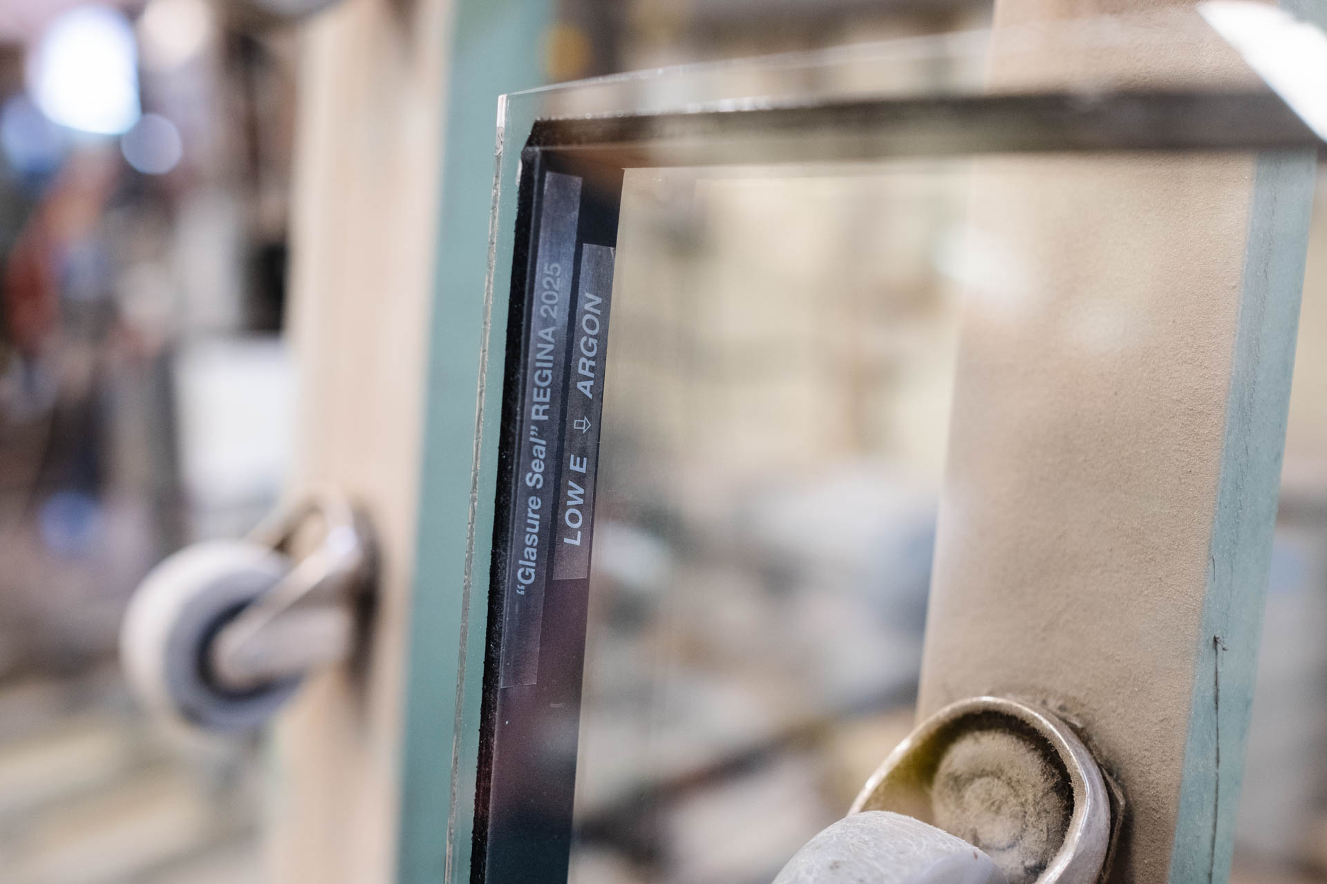Close-up of a Glacier Glass window pane corner featuring a Glasure Seal sticker labeled “Regina 2025, Low E Argon.
