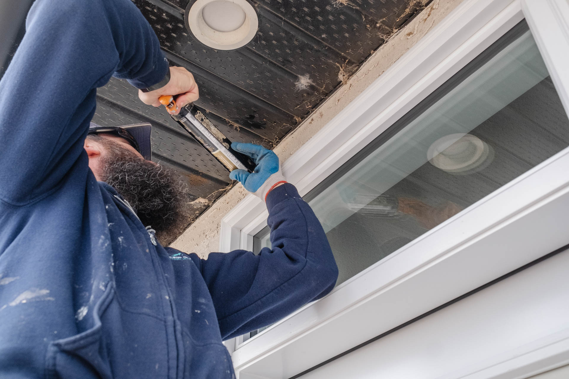 Glacier Glass employee applying caulking around a newly installed door to seal and finish the installation.