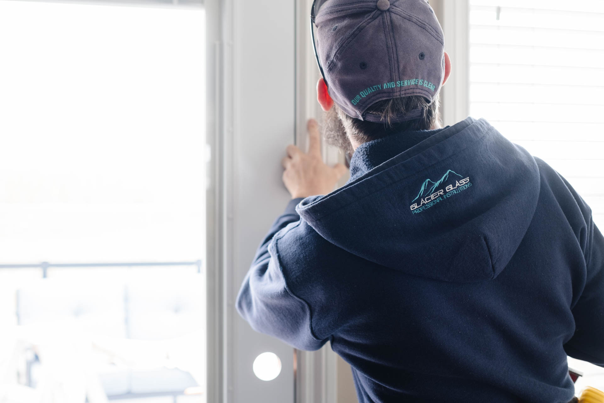 Medium 3/4 shot of a Glacier Glass technician repairing and installing a door on-site.