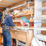 A bearded man in a blue hoodie and cap works with a miter saw on a workbench inside what appears to be a busy utility trailer or workshop, surrounded by various tools, equipment, and storage shelves. Glacier_Glass_Regina Glacier_Glass_Regina Glacier_Glass_Regina Glacier_Glass_Regina Glacier_Glass_Regina Glacier_Glass_Regina Glacier_Glass_Regina Glacier_Glass_Regina Glacier_Glass_Regina Glacier_Glass_Regina Glacier_Glass_Regina Glacier_Glass_Regina Glacier_Glass_Regina Glacier_Glass_Regina Glacier_Glass_Regina Glacier_Glass_Regina Glacier_Glass_Regina Glacier_Glass_Regina Glacier_Glass_Regina Glacier_Glass_Regina Glacier_Glass_Regina