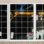 A three pane window with white grilles, set within a beige stucco wall above a brick ledge, offers a view of yellow scaffolding, a white bucket, a box of joint compound, and rectangular papers taped to the inside glass. Glacier_Glass_Regina Glacier_Glass_Regina Glacier_Glass_Regina Glacier_Glass_Regina Glacier_Glass_Regina Glacier_Glass_Regina Glacier_Glass_Regina Glacier_Glass_Regina Glacier_Glass_Regina Glacier_Glass_Regina Glacier_Glass_Regina Glacier_Glass_Regina Glacier_Glass_Regina